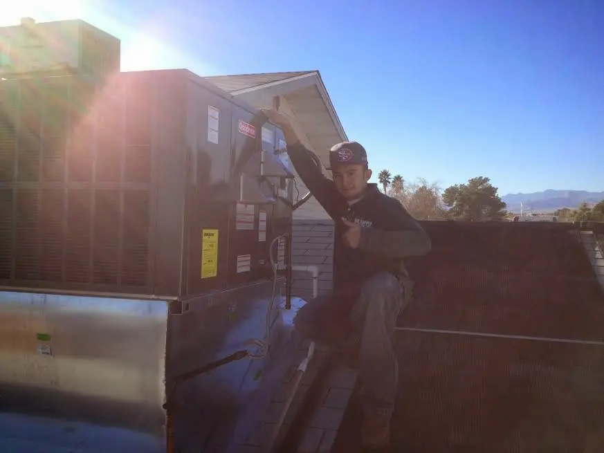 HVAC technician performing Air Duct Cleaning on a rooftop unit in New Baltimore